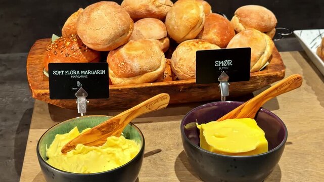 Fresh bread rolls with butter and margarine on buffet counter