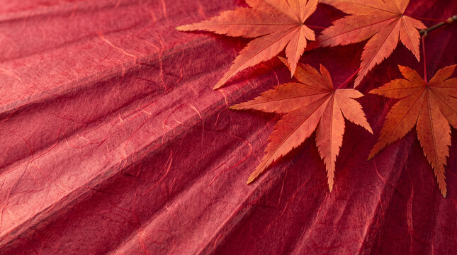 High angle view of traditional red Japanese paper umbrella texture with autumn red maple leaves in top right corner.