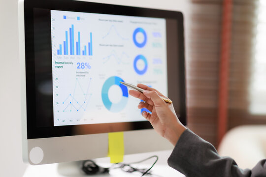 Business professional analyzing company performance on a computer display, examining financial graphs and charts for data analytics, market research, and strategic reporting
