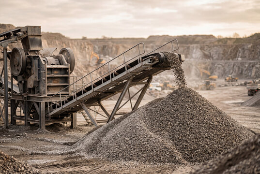 Stone crushing machine pouring gravel onto dirt pile