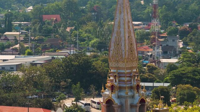 Aerial orbit ascend of Wat Chalong pagoda and ornate temple buildings, drone