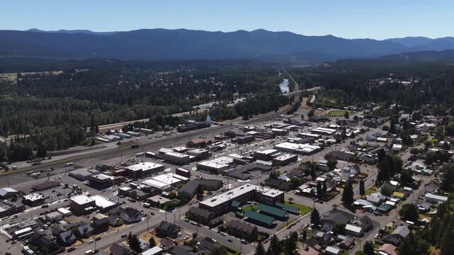Aerial of small town Cle Elum and forest in Kittitas County Washington with commercial district and train tracks in summer