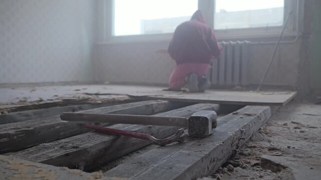 Low angle highlights demolition tools with dusty renovation scene in background
