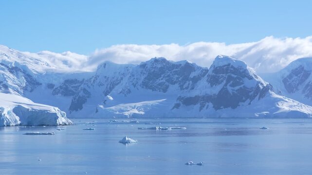 Cinematic Antarctica Mountains Covered in Snow and Glaciers. Epic Cruise Ship Wide View Clear Sunny Day in Wilhelmina Bay Calm Waters Blue Sky