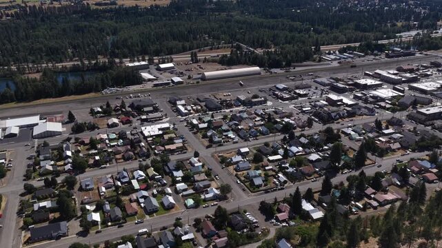 Aerial of residential and commercial area in small town Cle Elum Washington with dense housing development and large forest