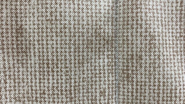 The light brown non-woven fabric features a texture with a fine-fiber pattern and natural speckles, making it suitable for use as a background.