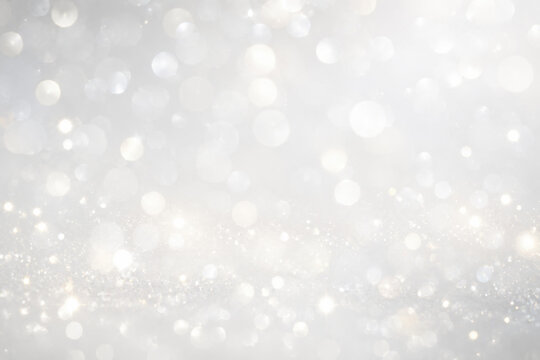 Abstract white silver glitter bokeh background with soft light glow