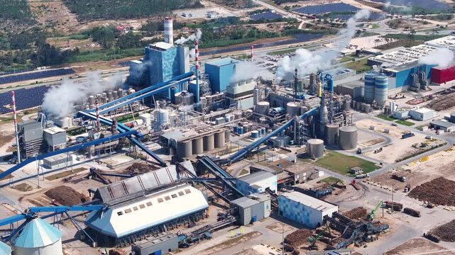 Industrial pulp and paper mill producing cellulose from wood. Aerial view of the factory complex with biomass power plant and smokestacks