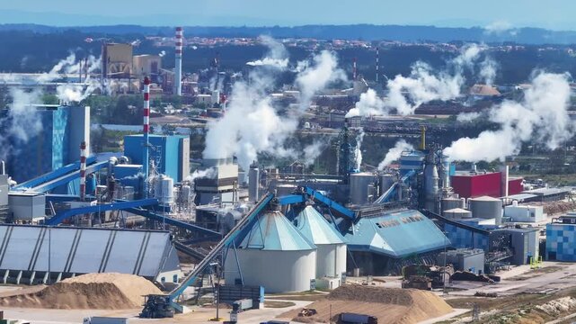 Extensive industrial complex of a pulp mill for cellulose production releasing steam and smoke into the atmosphere from its chimneys