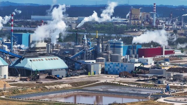 Large paper and pulp mill with smoking chimneys. This industrial plant produces cellulose from eucalyptus wood and generates bioenergy
