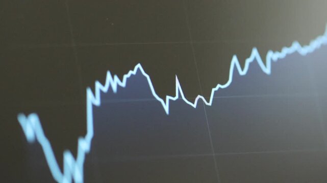 Horizontal 4K macro video showing a finger swiping across a green financial trend line on a dark digital display screen to view data metrics