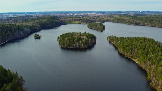Aerial drone view showing Stora Delsjon lake with forest covered islands surrounded by Gothenburg largest nature reserve