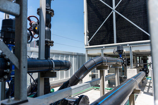 Industrial cooling tower pipe system and valves infrastructure on rooftop, Piping and control valves of a commercial HVAC water cooling system, Industrial plumbing pipeline network for factory