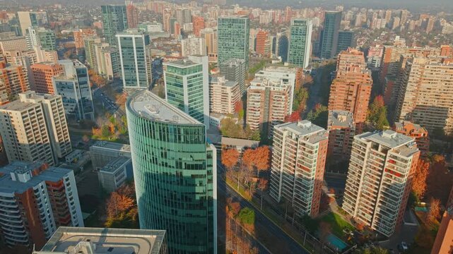 Dolly in flyover of modern office and residential buildings on a sunny day in Las Condes, Santiago, Chile