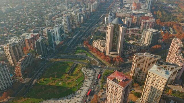 Aerial orbit establishing of Rene Schneider Square in Las Condes, Santiago, Chile, on a sunny day with a light mist; upper-middle-class residential buildings