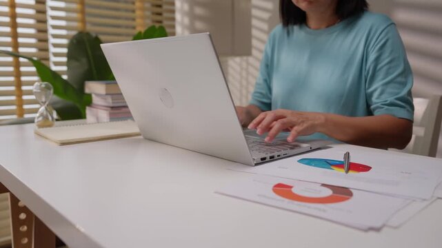 Close up shot of female hand using laptop for working, learning, searching, or surfing social media at home.