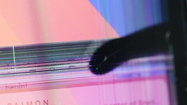 Horizontal 4K video showing distorted text elements, horizontal color bars, and heavy light flickering on a damaged laptop monitor screen edge