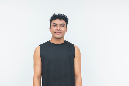 A young filipino male in a black tank top smiles warmly at the camera in a clean waist-up studio portrait.