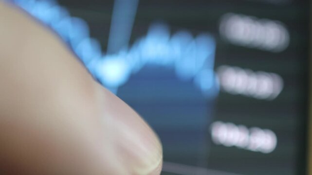 Horizontal 4K alternate angle shot of a finger flicking up and down to inspect stock list values on a smartphone trading application