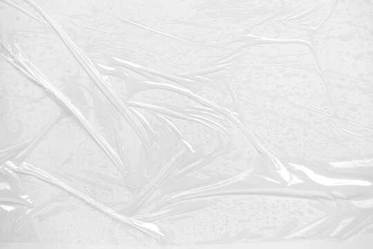 Plastic overlay texture of realistic crumpled transparent plastic film wrap on white background, wrinkled, stretched plastic effect. Abstract plastic background on transparent PNG