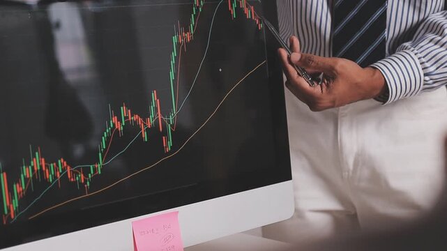 Two busy business men investors doing financial trading market data analysis. Male advisor and analyst consulting about stock exchange investing pointing at chart on laptop computer working in office.