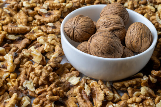 Whole Walnuts and Walnut Kernels in White Bowl