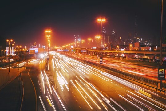 Panorama Dubai heavy night night traffic on Sheikh Zayed Road after work rush hour traffic. Light trails lead to the Burj Khalifa and Downtown Dubai cityscape at night landmarks skyline