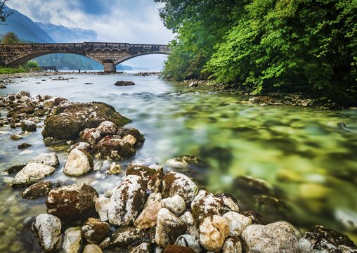 Panorama of Bohinj lake with rocks and silky lake water and the bridge on the background. Slovenia