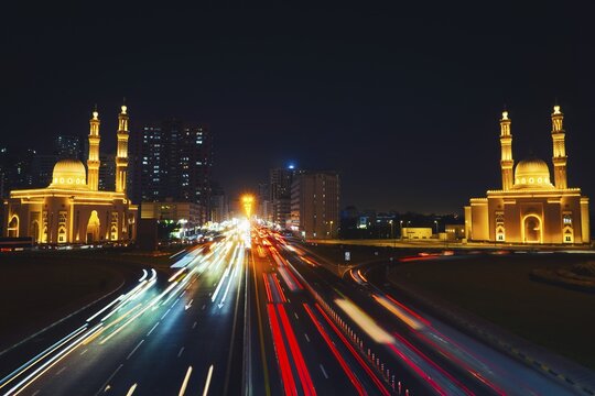 Night long exposure Sharjah Four Khalifas intersection.UAE futuristic architecture. Illuminated Masjid Abu Bakr Al Siddiq, Umar bin Al Khattab, Uthman bin Affan, Ali bin Abi Talib mosque light trails