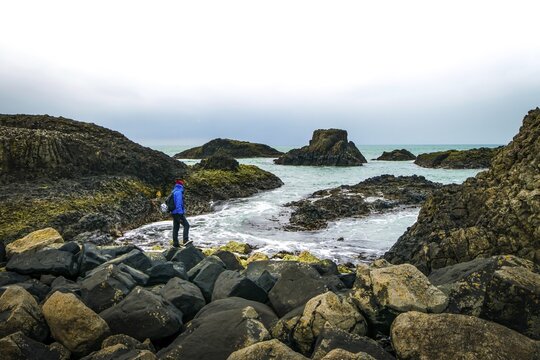 One person is stadig on rocky shore and looking to the sea. Northern Ireland