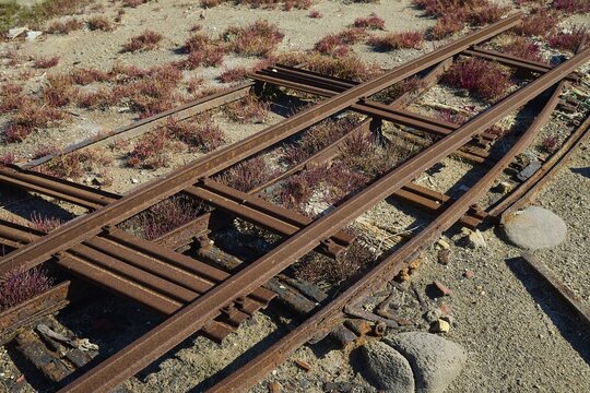 Rusted tracks run through a dry landscape covered with vegetation, saltworks, Lost Place, near airport, salt lake, Alykes Milou, Milos, Cyclades, Greek Islands, Greece