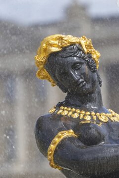 Detail of a bronze nymph from the Fontaine des Fleuves on the Place de la Concorde in Paris, decorated with golden ornaments and laurel wreath. The falling water envelops the figure and accentuates her mythological elegance and symbolic power, Paris, &Icirc;le-de-France, France