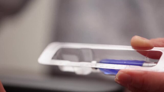 Medical professional removing GHK Cu peptide vial from sterile plastic blister packaging.