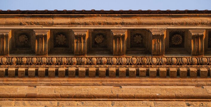 Detailed view of the intricately crafted roof cornice of Palazzo Strozzi, warm evening light, old town, Florence, Tuscany, Italy