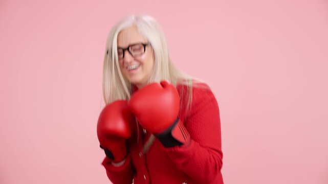 Senior woman fighting ageism with boxing gloves