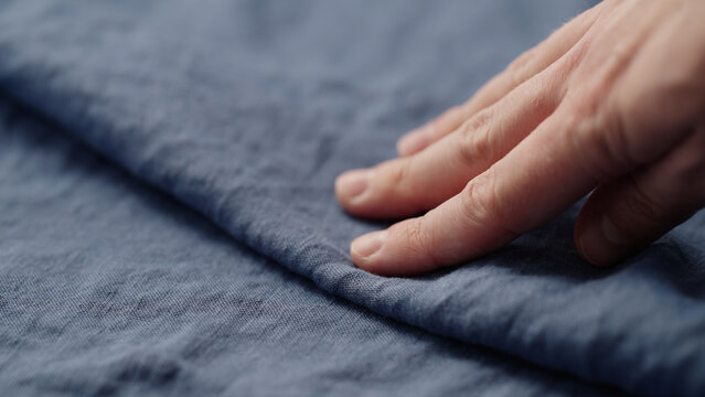 man hand checking blue linen shirt cloth
