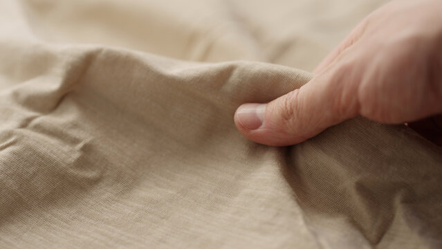 man hand checking natural cotton jersey cloth