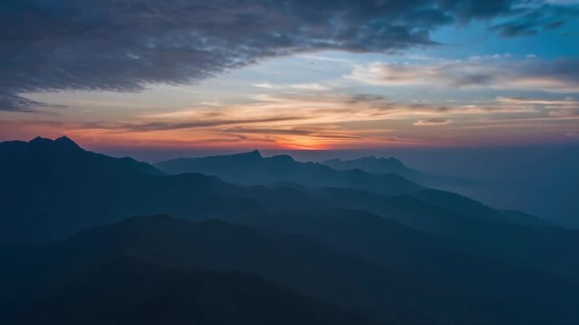 Peaceful Sunrise Landscape with Clouds and Mountain Peaks