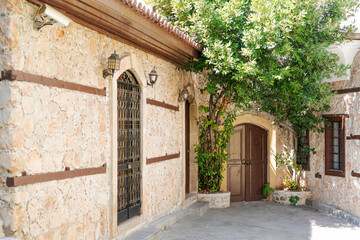 Fototapeta premium Stone Walled Old Town Alley with Arched Wooden Door at Antalya Kaleici