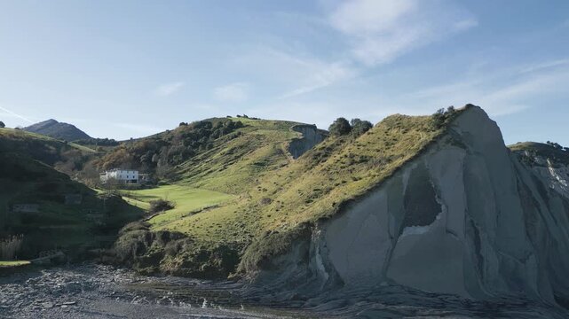 Aerial view of picturesque green coastal hills and steep sedimentary cliffs in flysch geological formation near Zumaia in Spain.