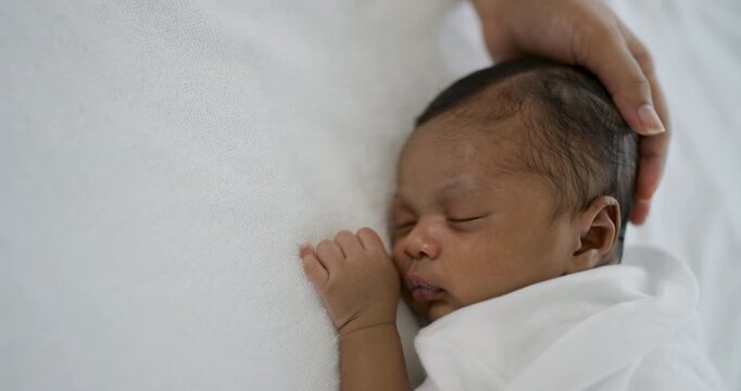 African black parent hands pad on newborn baby head, Closeup mother&rsquo;s hand holding their new born baby. Together love harmony family nursery healthcare and medical father&rsquo;s day concept