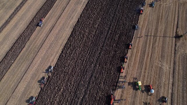 Drone view of long crop rows and tractors
