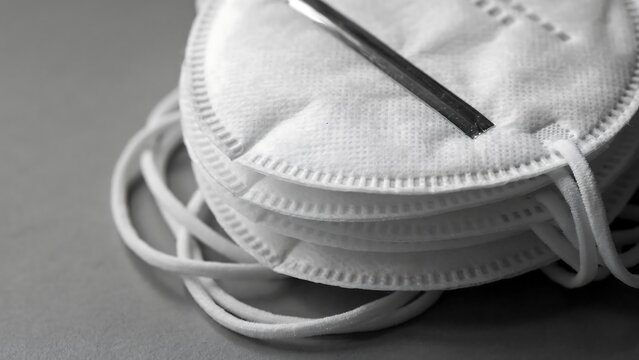 Stack of white protective n95 face masks on a grey background with protection