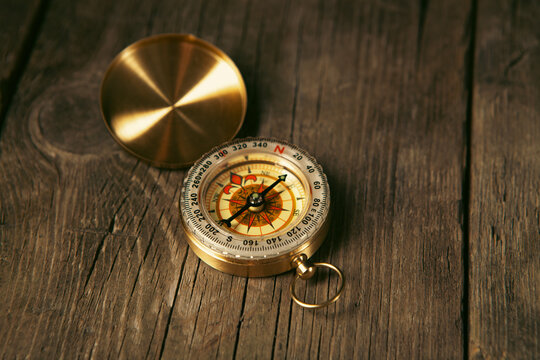 Compass on a wooden background. Vintage style toned picture.