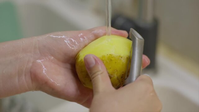 Peeling potatoes under running water