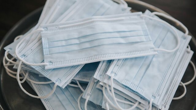 Stack of disposable protective face masks in tray with disposable, protective