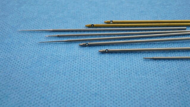 Set of various medical needles and cannulas on blue fabric background
