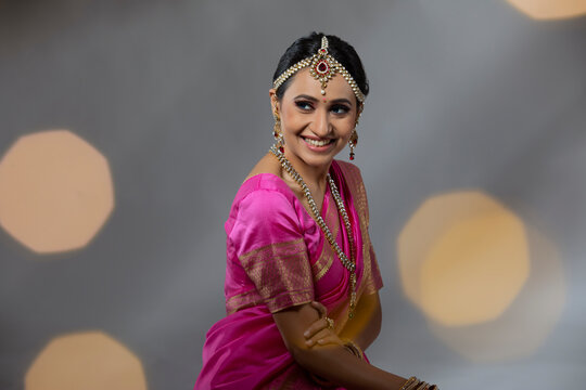 Portrait of a lady in a beautiful pink saree smiling 
