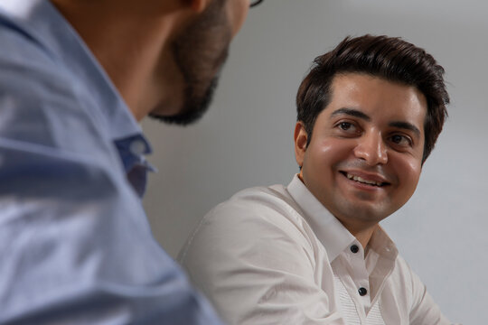 A YOUNG EXECUTIVE TALKING TO COLLEAGUE IN OFFICE
