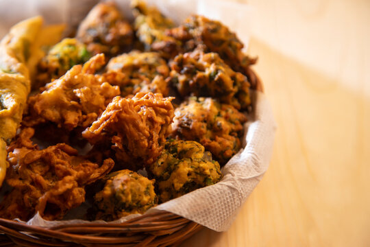 A basket filled with pakoras kept in a plate